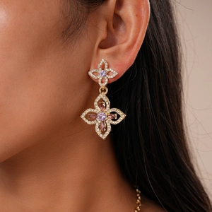 Close-up of luxury double-layer hollow flower earrings with gold finish and purple stones