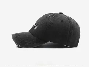 Detail of distressed baseball cap with white letter embroidery and vintage wash texture