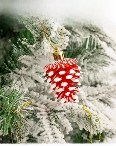 Détail macro d'ornements de pommes de pin rouges avec effet neige sur sapin de Noël