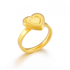 Detailed close-up of golden stainless steel ring with embossed heart and dot textures