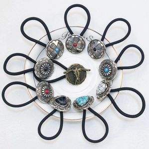 Set of Western-style hair ties with turquoise and bull head motifs on white plate