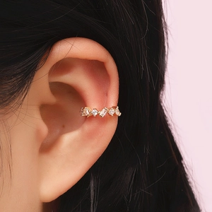 Close-up of gold ear cuff with sparkling cubic zirconia on a model's ear