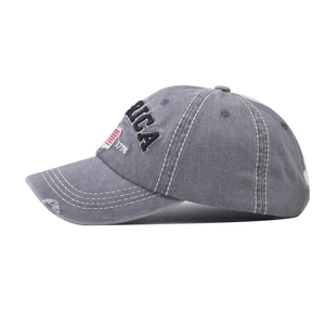 Detail of vintage washed grey baseball cap featuring America 1776 embroidery and distressed brim