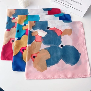 Three elegant satin square scarves with abstract floral patterns in pink, blue, and beige