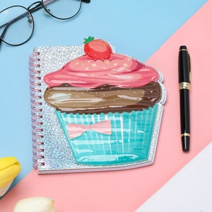 Macro shot of a cupcake-shaped notebook with pink metal spiral and glittery cover