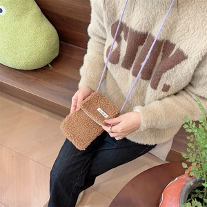 Brown faux shearling mini crossbody phone bag with flap and colorful label detail