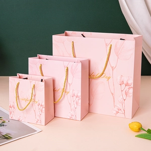 Pink paper gift bags in three sizes with leaf texture and golden rope handles