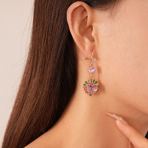Vintage gold heart earrings with pink zircon and multi-colored stones on a female model
