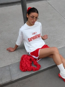 Street style λευκό βαμβακερό oversized μπλουζάκι με κόκκινα γράμματα και κόκκινη τσάντα