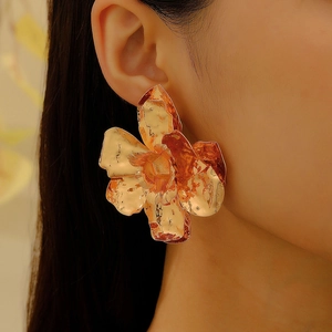 Vintage oversized gold flower stud earring with textured metal petals on elegant female model