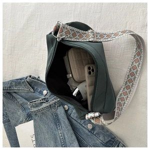 Interior view of dark green nylon bag showing space for wallet, phone and cosmetics