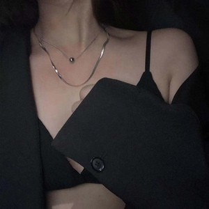 Dettaglio della collana a strati argentata a serpente con perline su modella in nero