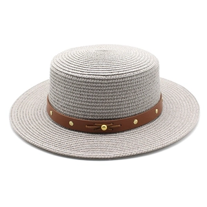 Détail du chapeau de paille gris avec ruban en cuir brun et rivets dorés en métal