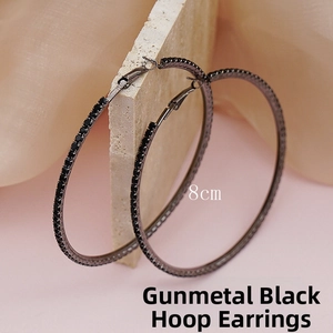 Macro detail of 8cm gunmetal black hoop earrings with sparkling black rhinestones