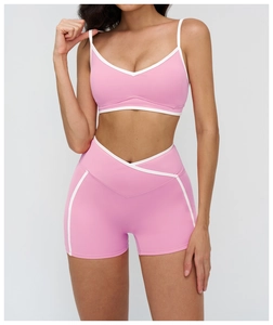 Close-up of pink sports bra and v-shaped high waist shorts with white piping detail