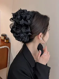 Vue détaillée d'une grande pince à cheveux en tulle noir avec design floral multicouche