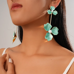 Bohemian large green flower earrings with faux pearls on model in close-up shot