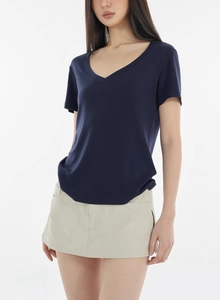 Detailed view of dark blue V-neck wool t-shirt with soft knitted texture on model