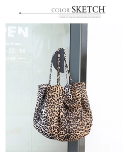 Detail view of leopard print tote bags in brown and white hanging on a door handle