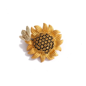 Golden sunflower and bee brooch featuring intricate metal texture and crystal accents