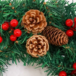 Couronne de Noël 30cm avec aiguilles de pin, cônes et baies rouges sur fond neige