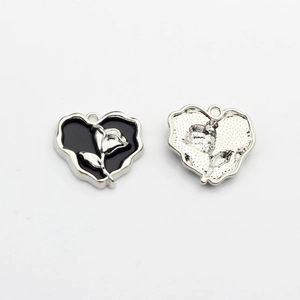 Front and back detail of heart charms with silver rose and black enamel inlay