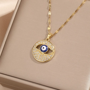 Close-up of golden Evil Eye pendant with cubic zirconia inlay in a jewelry box