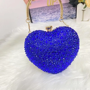 Close-up of heart-shaped evening bag featuring navy blue rhinestones and gold ring handle