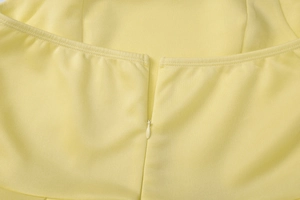 Macro della cerniera invisibile sul retro di un abito estivo giallo a vita alta