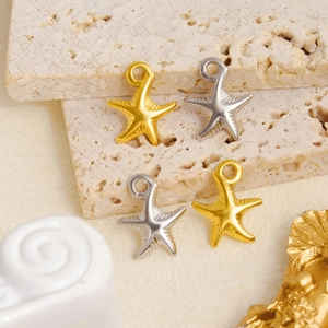 Macro shot of gold and silver starfish pendants made of 304 stainless steel on stone