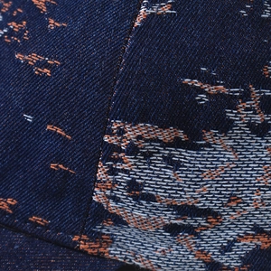 Macro detail of Chinese style embroidery and navy denim texture on baseball cap
