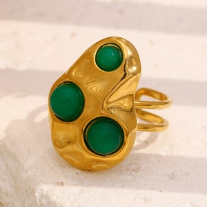 Detailed macro view of 18K gold plated hammered ring with three green gemstones