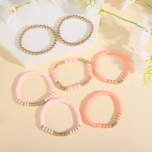 Pink and orange clay disc beads with gold alloy spacers in a 7-piece layered bracelet set