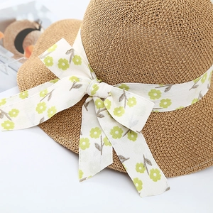 Women's woven straw sun hat with floral bow ribbon for summer beach UV protection