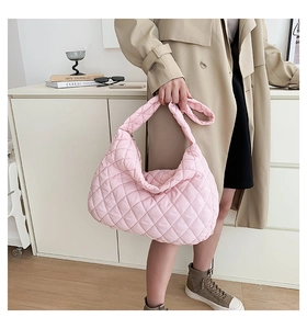 Pink quilted cloud shoulder bag featuring soft pleated fabric and a wide padded strap