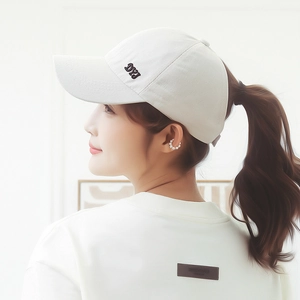 White high ponytail baseball cap with side cutout and pearl ear cuff detail on model