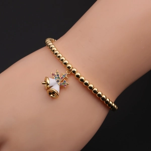 Detail eines Goldperlenarmbands mit weißen Emaille-Glocken und einem bunten Zirkonstern
