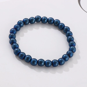 Detail shot of deep blue 8mm agate beads on a stretch bracelet with metallic finish