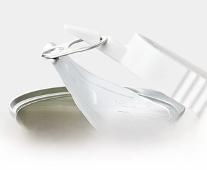 Close-up of a white multifunctional can opener using triangular tip to pry pop-top lids