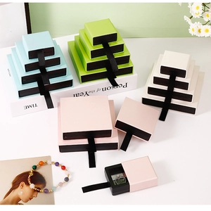 Close-up of pastel drawer-style jewelry gift boxes with elegant silk ribbons in multiple sizes
