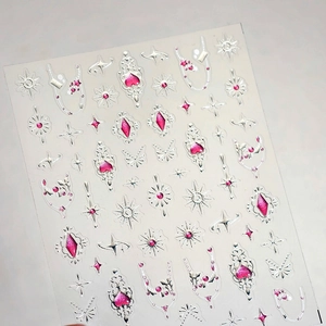 Macro view of Y2K style butterfly and star nail stickers with silver glitter and pink gems