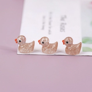 Macro shot of mini resin ducks with champagne pink glitter finish for DIY crafts