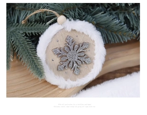 Detail of wooden Christmas ornament with glitter snowflake and white faux fur trim on pine