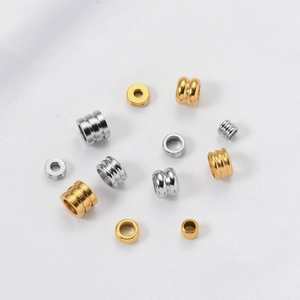 Dettaglio di perline distanziatrici in acciaio inossidabile oro e argento con design a strati