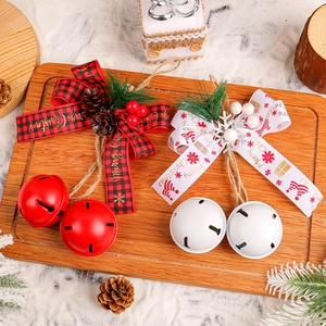 Christmas iron bells with plaid bows and pine cones on a wooden tray for tree decoration