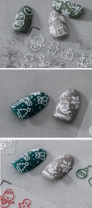 Close-up of 3D embossed Christmas nail stickers featuring snowmen and reindeer patterns