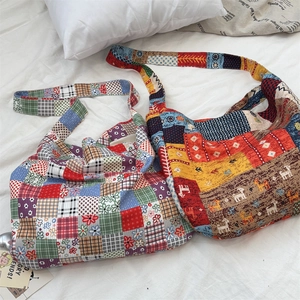 Top view of two vintage patchwork canvas shoulder bags on a clean white bed linen