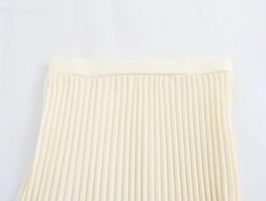 Detailed view of cream-colored pleated midi skirt fabric texture and soft pleat design