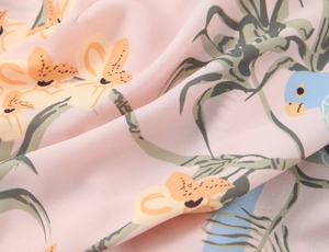 Gros plan sur tissu mousseline rose avec motifs floraux et d'oiseaux très légers