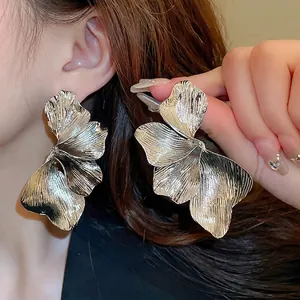 Chic silver petal-shaped earrings with textured metallic finish worn by model